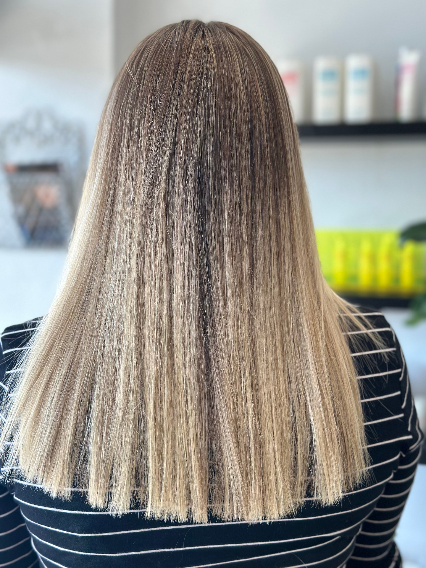 Sleek straight blonde balayage with smooth shiny finish
